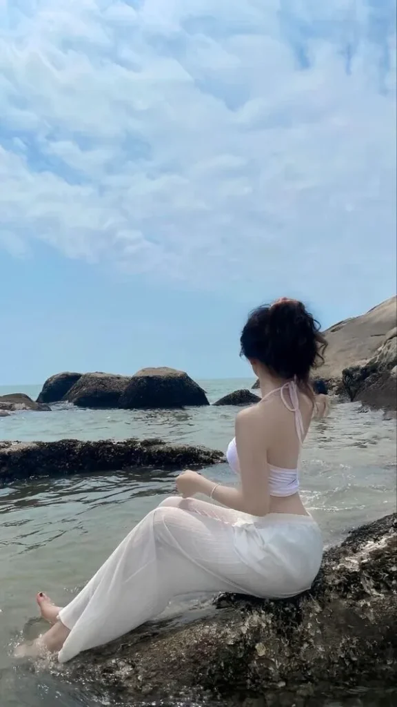 Thành bể tạo đường nét thẳng, cô gái che mặt, bikini dây buộc, dáng nghiêng mềm, cảm giác sạch và nóng.