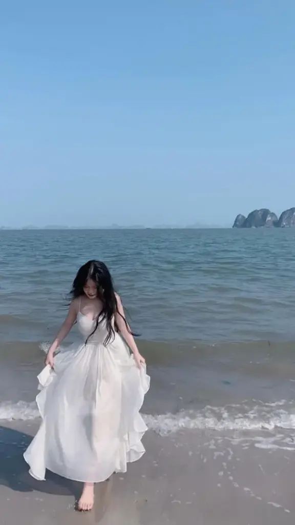 Nàng diện váy voan mỏng chạy dọc bờ biển, tóc bay, bước chân nhẹ như lướt.