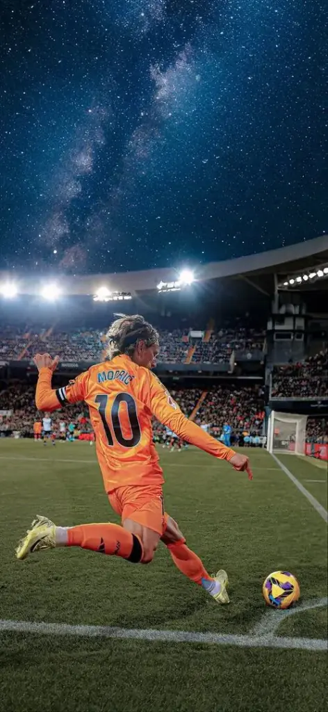 Tấm Hình nền điện thoại bắt trọn khoảnh khắc cầu thủ ăn mừng trên thảm cỏ xanh mướt dưới ánh đèn sân đêm tạo ra một khoảnh khắc vàng rực rỡ.