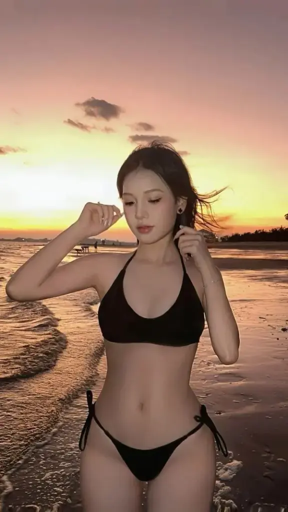 Hoàng hôn bãi biển, đường cong lên nét, tóc bay, gương mặt ấm, vòng eo gọn làm ảnh dịu lại